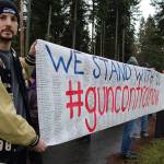 Brook Willeford holds one end of a scroll listing the names of mass shootings victims since 1966. Katrina Bentsen, a 1998 SWHS graduate, made the sign based on a <em>Washington Post </em>compilation.