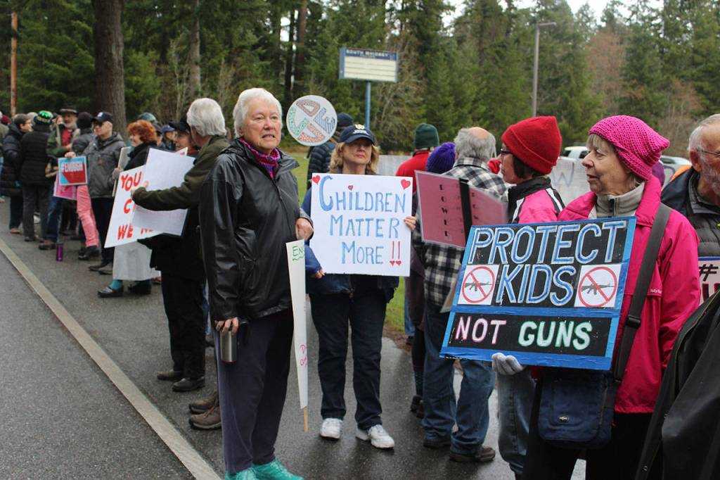 South Whidbey High School parents and other supporters joined in Wednesdays national Enough school walkout aimed at reducing gun violence and remembering 17 students and faculty killed in Florida last month. They lined the road in front of the closed campus where students gathered.
