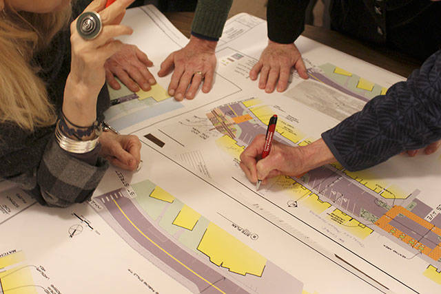 Langley residents look over different blueprints for redesigning Front Street parking at a city meeting. Divided into small groups, they wrote comments and also read suggestions.
