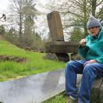Hank Nelson sits near one of his installations at Cloudstone Sculpture Park, a 20-acre display near Freeland of his stone and steel work. Nelson and artist Sue Taves are being honored April 21 during International Sculpture Days. Photo by Patricia Guthrie/Whidbey News Group