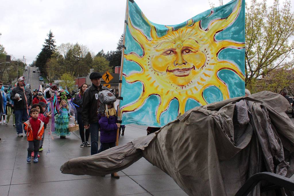 Marchers walk behind the whale tail end of an electric scooter that carried elderly parade-goers. The whale tail, or flukes, are all thats left of the original parade whale named Gary the Gray Whale.