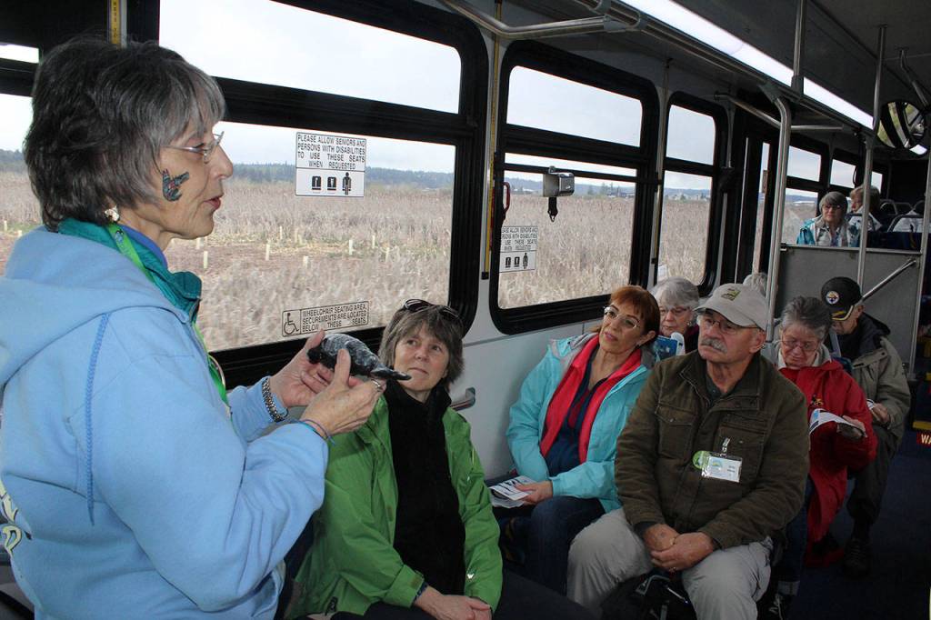 Whale naturalist Bonnie Gretz talks about the pods of killer whales in Puget Sound. Island Transit tour leader Maribeth Crandell is to the left of Gretz wearing a green coat.