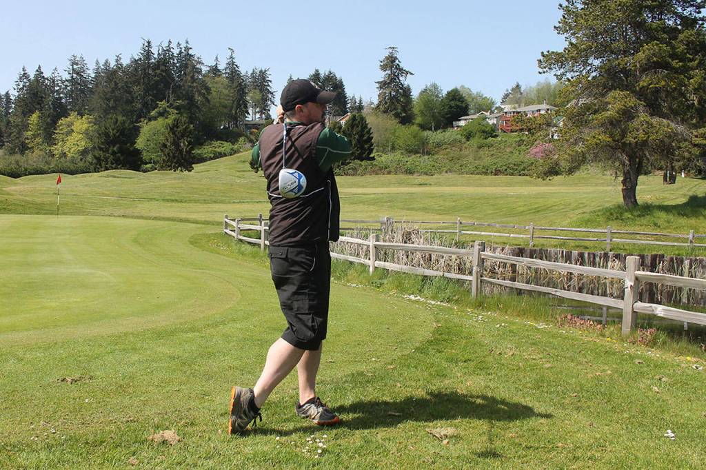 Holmes Harbor Golf Club operator Paul Lavin practices his swing near the 18th hole. Lavin is also a professional golfer available to teach.