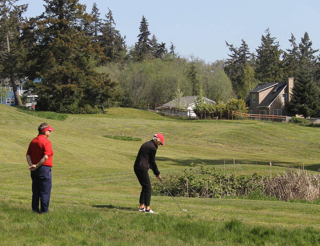 Marsha Coolidge looks on as Nancy Lawless concentrates on her next shot. The Womens Golf Club of Holmes Harbor meets every Thursday at 9 a.m. to play 18 holes.