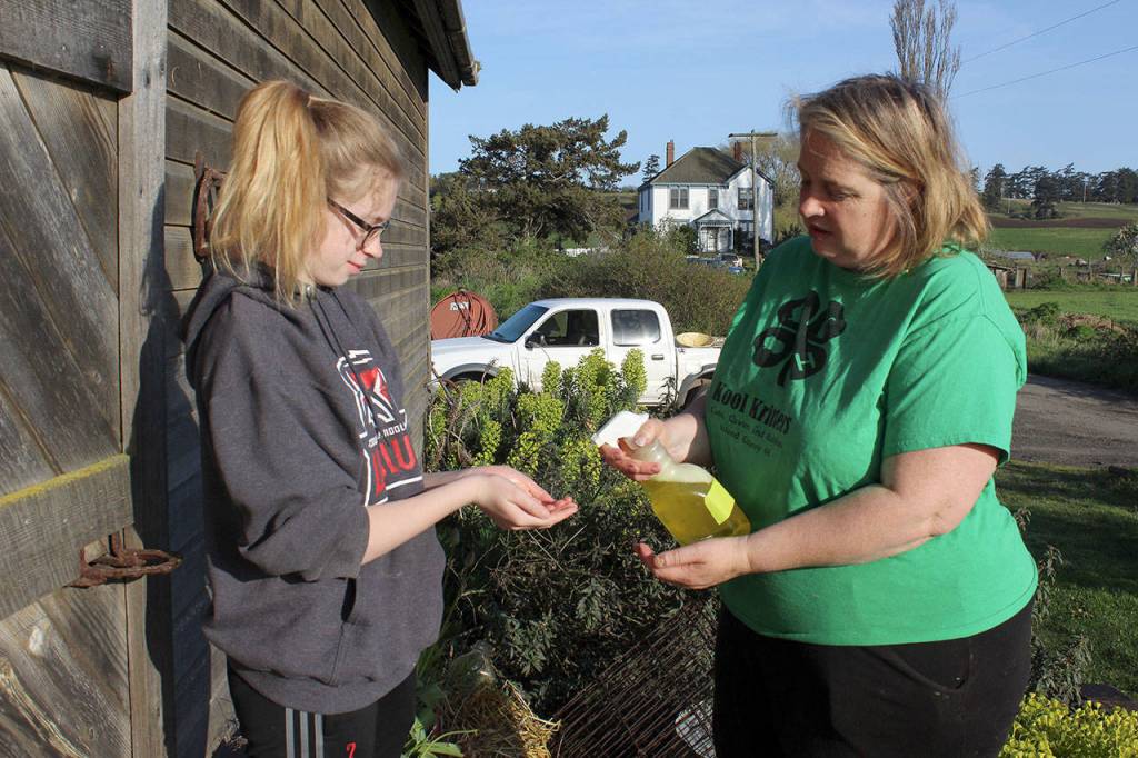 Wynter Arndt and her mother, Georgie Smith, leader of the Kool Kritters 4-H, apply disinfectant to their hands and the bottom of their shoes before handling any rabbits. Its one of several recommended precautions.