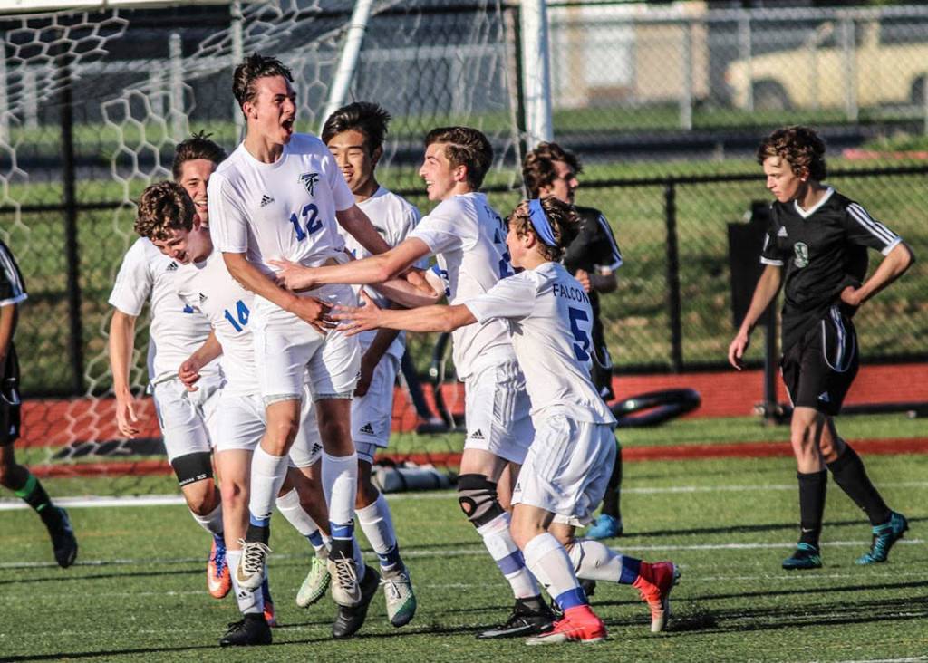 Nevin Daniels (12) is mobbed by his teammates after scoring a goal. (Photo by Matt Simms)