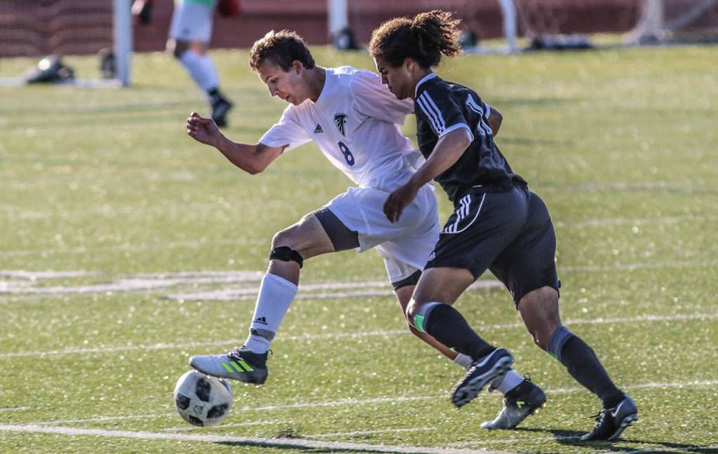 Joey Lane moves the ball by an Eagle defender.(Photo by Matt Simms)
