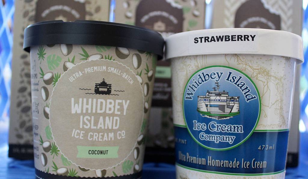 The old blue and white logo of Whidbey Island Ice Cream Company is surrounded by its new design that uses colors and graphics to match the many flavors.                                A new design (left) for Whidbey Island Ice Cream Company will appear on products starting this week. It retains a drawing of a ferry, which became the symbol of the company a decade ago.