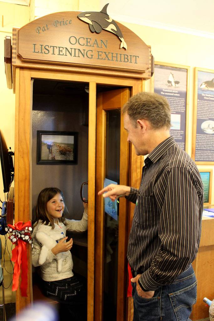 Scott Price and his daughter, Lydia, try out the Pat Price Ocean Listening Booth at the Langley Whale Center. They narrated for the computerized exhibit thats named in honor of their mother and grandmother.