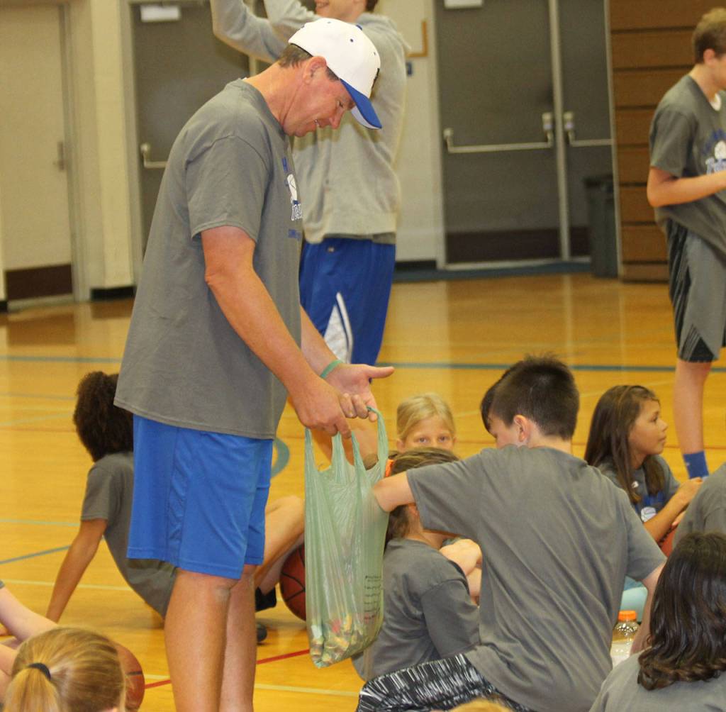 Girls head coach Jeff Hanson offers candy to a camper who correctly performed a designated skill.(Photo by Jim Waller/South Whidbey Record)