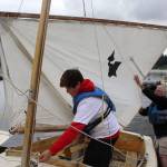 Evan Chappelle checks the rigging of his sailboat before heading out during a youth class on Deer Lake. Because of his size, Chappelle opted to learn on a longer Pelican boat than the 8-footer El Toros used by other students.