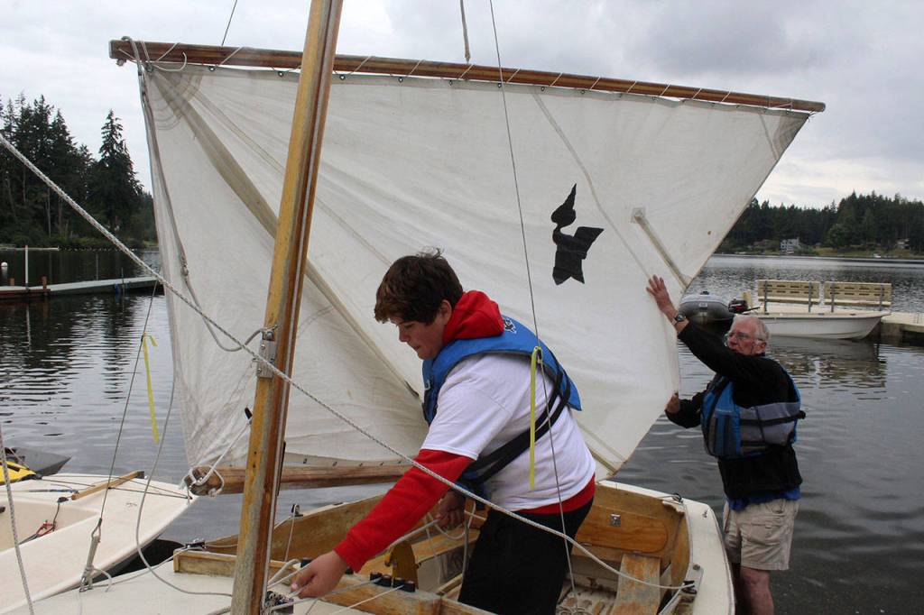 Evan Chappelle checks the rigging of his sailboat before heading out during a youth class on Deer Lake. Because of his size, Chappelle opted to learn on a longer Pelican boat than the 8-footer El Toros used by other students.