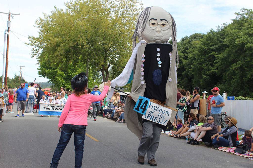 Photos by Patricia Guthrie / Whidbey News Group                                A girl gives a high-five to really tall Benjamin Franking during the Maxwelton Fourth of July Parade.