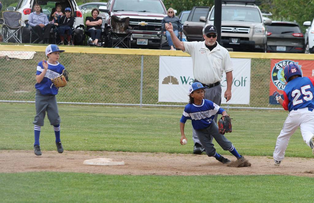 South Whidbey shortstop Jacob Hughes puts on the brakes after racing to touch second base for a force out as second baseman Alexander Zarifis looks on.(Photo by Jim Waller/South Whidbey Record)