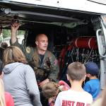 Cody Wall, a member of Search and Rescue from Naval Air Station Whidbey Island, answers questions from a group of children Thursday at Camp Casey Conference Center. The unit landed its helicopter on the camps field to as part of Sea Cadet summer training. The aircraft drew the attention of others present at the camp as well. Photo by Laura Guido/Whidbey News-Times