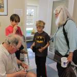 At the end of the three-day Model Rocket Mini Camp, Leonard Good attends to a last-minute repair request of Caleb Arndt (wearing Batman shirt) as his brother, Griffin, and grandmother, Bonnie Arndt, look on. The boys father took the same class from Good 35 years ago.