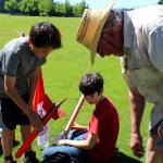 Leonard Good helps Jamie Dale (left) and Liam OBrien (center) prepare their spacecraft for flight.