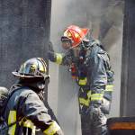 Lt. James Meek, of Central Whidbey Island Fire and Rescue, stands in the doorway of a house on Classic Road destroyed by a fire Wednesday. Photo by Laura Guido/Whidbey News Group