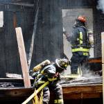 Lt. James Meek and another firefighter from Central Whidbey Island Fire and Rescue, work to extinguish the last of the flames Wednesday on an uninhabited house on Classic Road. Photo by Laura Guido/Whidbey News Group