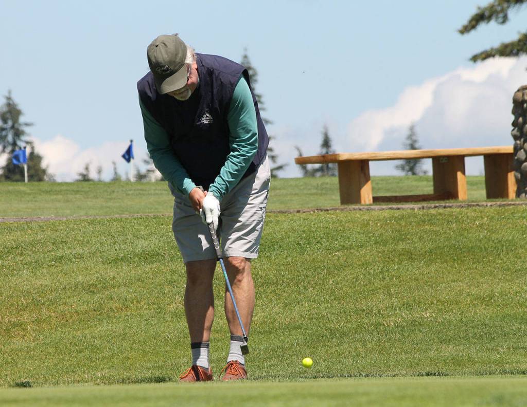 John Williams attempts to sink a putt on the ninth hole.(Photo by Jim Waller/South Whidbey Record)