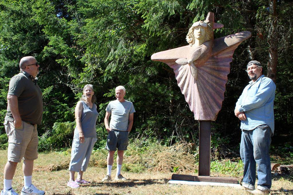 South Whidbey residents chat with artist Alexei Kazantsev (right) as they look over his recently-installed sculpture of Amelia Earhart near a small airstrip. (Photo by Patricia Guthrie/Whidbey News Group)
