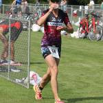 Christina Bromme grabs a drink while tranistioning from biking to running at the triathlon. (Photo by Jim Waller/Sound Whidbey Record)