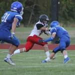 South Whidbey defenders box in a Coupeville running back in last years season opener. The game was a non-league contest last fall, but the two teams will compete in the same conference this season. (Photo by Evan Thompson