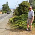 The paving project on Second Street in Langley will extend asphalt to private property lines. Public Works Director Stan Berryman stands where some vegetation will have to be removed. (Photo by Patricia Guthrie/Whidbey News Group)