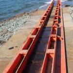 Two bright orange metal tracks extending from the shipyard to the sea will bear the weight of the 1,700-ton vessel.