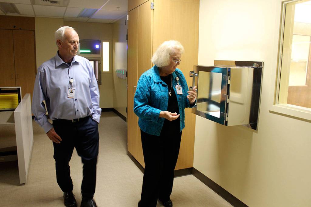 WhidbeyHealth board commissioners Ron Wallin and Nancy Fey look into the sterile chambers for mixing drug compounds in the new hospital pharmacy slated to open soon. (Photo by Patricia Guthrie/Whidbey News Group)