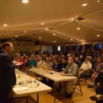 Rep. Dave Hayes speaks to an overflow, standing-room-only crowd packing Clinton Community Hall Monday night. Eight candidates answered questions presented by the League of Women Voters and Clinton Community Council. (Photo by Patricia Guthrie/Whidbey News Group)