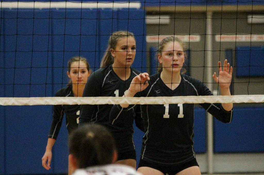 Alyssa Ludtke, left, Emma Leggett and Emma Hodson get ready to rotate on a serve.(Photo by Jim Waller/South Whidbey Record)
