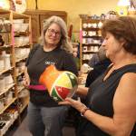 Catherine Vance, right, looks over her finished vase she painted at Whidbey Art Escape with encouragement from owner Tina Beard, left.