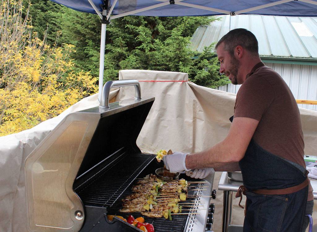 Chef Wayne Carter tends to skewers of chicken, peppers and pineapple on the patio grill. Hes using the temporary outside grilling area until the interior stove is completely installed.