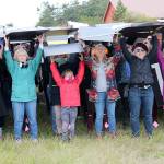 Photo by Jessie Stensland / Whidbey News Group                                A crowd at a rally against Growler noise in Central Whidbey Wednesday participated in a card stunt.