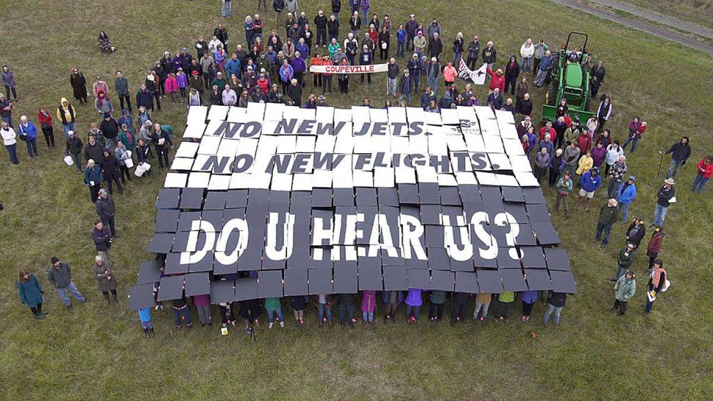 Photo courtesy of Sound Defense Alliance                                Nearly 200 people concerned about Growler jet noise participated in a card stunt outside the Crockett Barn Wednesday.
