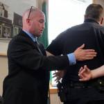 Glen Carpenter, an expert in use of force by law enforcement officers,demonstrates handcuffing techniques on former Langley police chief David Marks at a city council meeting earlier this year.