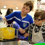 Weston Klamm, left, and Wyatt Embleton add more ingredients to the pumpkin pie mix.