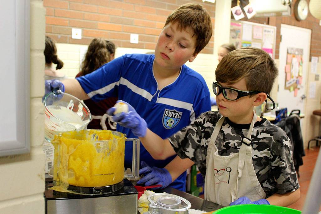 Weston Klamm, left, and Wyatt Embleton add more ingredients to the pumpkin pie mix.