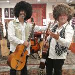 Troy Chapman, left, and Andre Feriante try on some Turkmenistan hats while posing for photos at Music for the Eyes in Langley. (Photo provided by Julie Quiring)