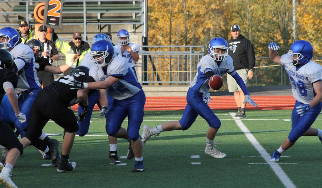 Falcon quarterback Kody Newman fakes a handoff to Caden Spear on a play-action pass.(Photo by Jim Waller/South Whidbey Record)