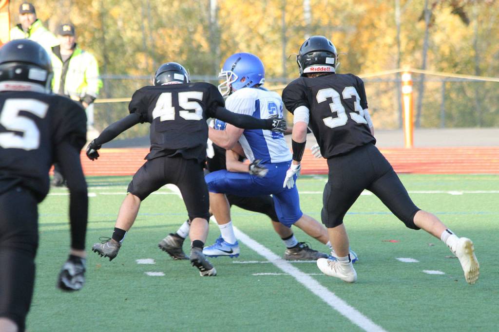 Caden Spear looks for some running room as Meridians Tanner Bouwman (45) and Dylan Hickok (33) close in.(Photo by Jim Waller/South Whidbey Record)
