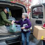 Tony Aguilar arranges donations handed to him by Jean Beers, center, and Norma Hansson. This is the third year that parishioners from three South Whidbey churches donated new clothes, personal care items and other needs for residents of Western State Hospital. (Photo by Patricia Guthrie/Whidbey News Group)