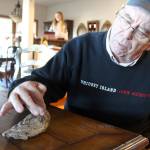 Kirk Lacewell looks at the fossilized tooth of a mammoth estimated to be 13,000 years old by University of Washington paleontologists. (Photo by Patricia Guthrie/Whidbey News Group)
