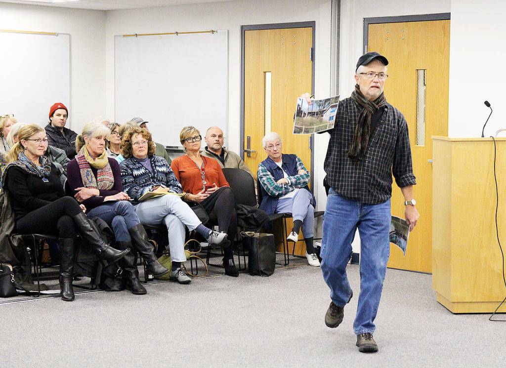 Mike Holata Monday shows the Island County Planning Commission a photo taken from his deck of the Comforts of Whidbey winery to illustrate the proximity and its impact. The public hearing on proposed rural event regulations was dominated by neighbors of the Langley winery. Photo by Laura Guido/Whidbey News Group