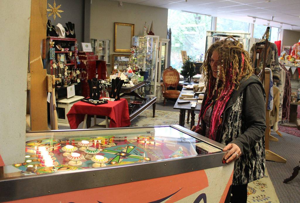 Carie Elder takes a couple minutes to play the vintage pinball machine at her new store, Whidbey Wonders. Its available for those not so much into shopping.