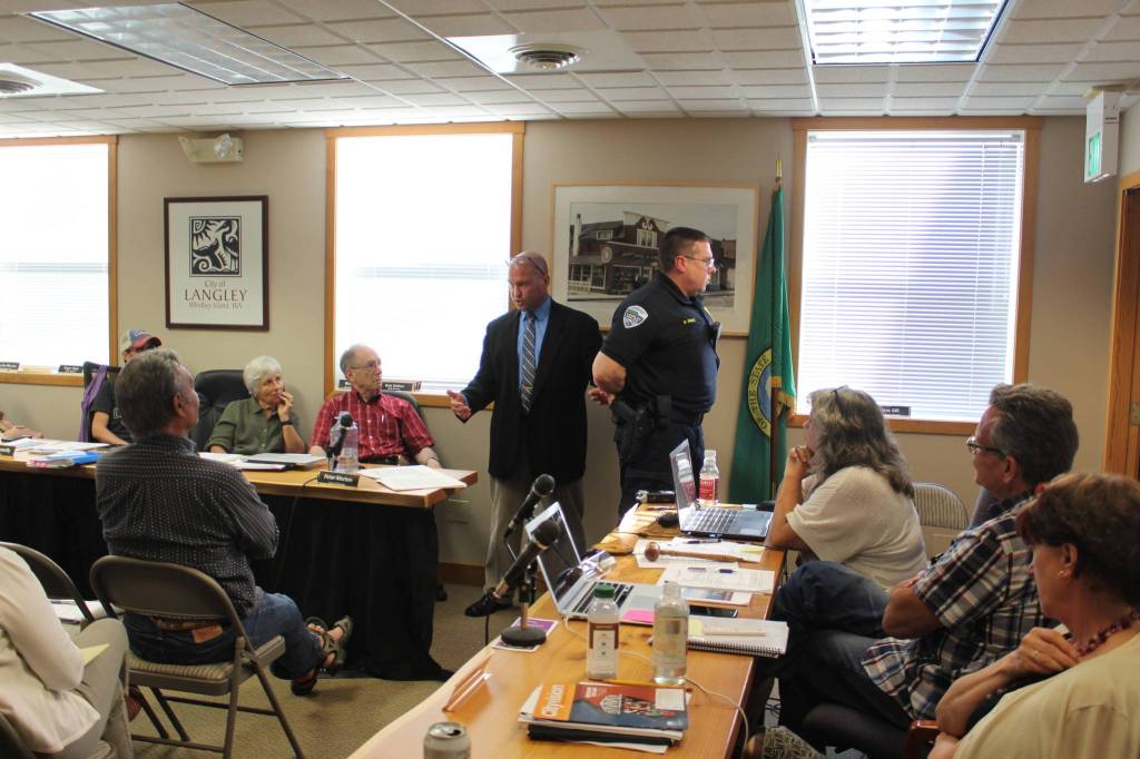 At a Langley city council meeting in June, Robert Glen Carpenter with the Pierce County Sheriffs office, and labled an expert in use of force by law enforcement officers, demonstrates proper handcuffing technique on Police Chief David Marks. By years end, both men lost their jobs.