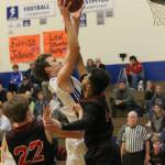 Levi Buck shoots over the defense of Coupeville Jakobi Pilgrim. (Photo by Jim Waller/ South Whidbey Record)