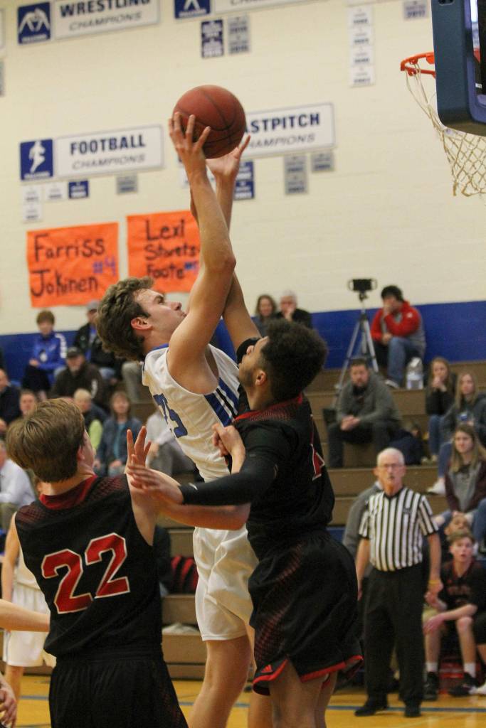 Levi Buck shoots over the defense of Coupeville Jakobi Pilgrim. (Photo by Jim Waller/ South Whidbey Record)