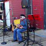 Peter Lawlor plays sea shanties on his concertina and harmonica on the Coupeville wharf during a birthday party for the historic schooner, Suva. (Photo by Patricia Guthrie/Whidbey News Group)